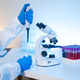 Scientist Using Pipette and Microscope in Medical Laboratory with Blood Sample Tubes Scientist Using Pipette and Microscope in Medical Laboratory with Blood Sample Tubes - PhotoDune Item for Sale