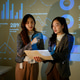 Two Businesswomen Discussing Data Charts During Corporate Presentation with Projected Dashboard Two Businesswomen Discussing Data Charts During Corporate Presentation with Projected Dashboard - PhotoDune Item for Sale