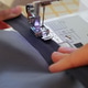 Close up Foot Sewing Machine Sews Dark Blue Fabric. Person Seamstress Creates Handmade Clothes. Close up Foot Sewing Machine Sews Dark Blue Fabric. Person Seamstress Creates Handmade Clothes. - PhotoDune Item for Sale