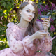 A portrait of a young woman with long hair in a pink dress among blooming lilacs. She sits with a gl A portrait of a young woman with long hair in a pink dress among blooming lilacs. She sits with a gl - PhotoDune Item for Sale