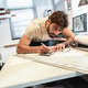 A print shop worker is preparing vinyl cutouts for application, carefully arranging them on transfer A print shop worker is preparing vinyl cutouts for application, carefully arranging them on transfer - PhotoDune Item for Sale
