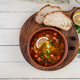 Bowl of traditional Solyanka soup with mixed meats and olives. Hearty homemade Eastern European dish Bowl of traditional Solyanka soup with mixed meats and olives. Hearty homemade Eastern European dish - PhotoDune Item for Sale