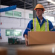 Warehouse Worker Wearing a Safety Helmet and High-visibility Vest Sealing Cardboard Boxes Packing Ta Warehouse Worker Wearing a Safety Helmet and High-visibility Vest Sealing Cardboard Boxes Packing Ta - PhotoDune Item for Sale