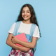 Smiling schoolgirl with backpack and notebooks in hands looking at camera on studio background Smiling schoolgirl with backpack and notebooks in hands looking at camera on studio background - PhotoDune Item for Sale