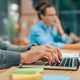 Close-up shot of office desk with a laptop and notebooks, while a male's hands are typing Close-up shot of office desk with a laptop and notebooks, while a male's hands are typing - PhotoDune Item for Sale