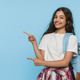 Schoolgirl with backpack looking at camera and pointing at copy space on blue studio background Schoolgirl with backpack looking at camera and pointing at copy space on blue studio background - PhotoDune Item for Sale