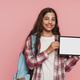 Smiling schoolgirl showing tablet with empty screen on pink studio background Smiling schoolgirl showing tablet with empty screen on pink studio background - PhotoDune Item for Sale