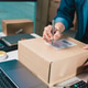 Person Completing Shipping Documentation for E-commerce Parcel Fulfillment at Home Office Person Completing Shipping Documentation for E-commerce Parcel Fulfillment at Home Office - PhotoDune Item for Sale