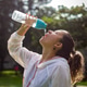 Woman hydrating with water bottle after outdoor workout Woman hydrating with water bottle after outdoor workout - PhotoDune Item for Sale