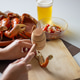 Person cracking crab claw with wooden mallet and beer Person cracking crab claw with wooden mallet and beer - PhotoDune Item for Sale