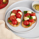 Bruschetta with mozzarella, cherry tomatoes, and basil on a serving board Bruschetta with mozzarella, cherry tomatoes, and basil on a serving board - PhotoDune Item for Sale