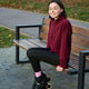 Woman seated in rollerblades on wooden bench, smiling to camera in burgundy fleece Woman seated in rollerblades on wooden bench, smiling to camera in burgundy fleece - PhotoDune Item for Sale
