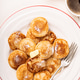 Small Dutch pancakes poffertjes served on a white plate with butter and coffee on the side Small Dutch pancakes poffertjes served on a white plate with butter and coffee on the side - PhotoDune Item for Sale