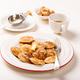 Dutch small pancakes poffertjes served with butter and coffee on a white plate with sugar cubes Dutch small pancakes poffertjes served with butter and coffee on a white plate with sugar cubes - PhotoDune Item for Sale