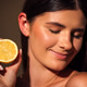 Young woman with long dark hair holds a fresh lemon close to her face, showcasing a natural glow and Young woman with long dark hair holds a fresh lemon close to her face, showcasing a natural glow and - PhotoDune Item for Sale