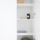 Minimalist white cabinet interior featuring neatly arranged shelves with decorative items, a black j Minimalist white cabinet interior featuring neatly arranged shelves with decorative items, a black j - PhotoDune Item for Sale