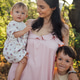 Mother holding toddler and young boy in a sunlit outdoor setting, surrounded by greenery, showcasing Mother holding toddler and young boy in a sunlit outdoor setting, surrounded by greenery, showcasing - PhotoDune Item for Sale