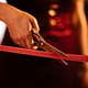 Woman in a burgundy dress cutting red ribbon with scissors during a ceremonial event, showcasing the Woman in a burgundy dress cutting red ribbon with scissors during a ceremonial event, showcasing the - PhotoDune Item for Sale