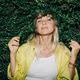 An attractive mid adult woman stands with her back to a hedge, looking at the camera. An attractive mid adult woman stands with her back to a hedge, looking at the camera. - PhotoDune Item for Sale