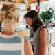 Two women are reading the menu at the counter in a café. Two women are reading the menu at the counter in a café. - PhotoDune Item for Sale