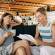 Two women are sitting discussing work plans in cafe. Discussion education about project with a stude Two women are sitting discussing work plans in cafe. Discussion education about project with a stude - PhotoDune Item for Sale