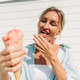 Woman enjoying a melting strawberry ice cream cone on a sunny summer day by the seaside Woman enjoying a melting strawberry ice cream cone on a sunny summer day by the seaside - PhotoDune Item for Sale