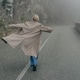 Woman in a coat on a rural road in foggy weather. Woman in a coat on a rural road in foggy weather. - PhotoDune Item for Sale