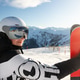 Woman skier holds red ski looks with reflective goggles showing snowy resort. Bright sunlight alpine Woman skier holds red ski looks with reflective goggles showing snowy resort. Bright sunlight alpine - PhotoDune Item for Sale