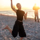Joyful teen child dancing barefoot sandy beach during warm sunset, expressing freedom, movement, ene Joyful teen child dancing barefoot sandy beach during warm sunset, expressing freedom, movement, ene - PhotoDune Item for Sale