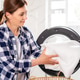 Adult woman loads white laundry in modern washing machine Adult woman loads white laundry in modern washing machine - PhotoDune Item for Sale