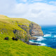 Summer landscape with vibrant green meadows by the ocean on Faroe Islands, Denmark. Summer landscape with vibrant green meadows by the ocean on Faroe Islands, Denmark. - PhotoDune Item for Sale