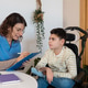 Nurse caring for boy with cerebral palsy in wheelchair Nurse caring for boy with cerebral palsy in wheelchair - PhotoDune Item for Sale