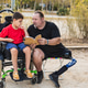 Adult with prosthetic leg reading to boy in wheelchair Adult with prosthetic leg reading to boy in wheelchair - PhotoDune Item for Sale