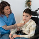 Nurse supporting boy with cerebral palsy in wheelchair Nurse supporting boy with cerebral palsy in wheelchair - PhotoDune Item for Sale