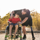 Man with prosthetic leg supporting child in wheelchair Man with prosthetic leg supporting child in wheelchair - PhotoDune Item for Sale