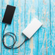 Charging a smartphone with a power bank on a wooden table Charging a smartphone with a power bank on a wooden table - PhotoDune Item for Sale