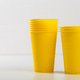 Yellow cups stacked on a table with a plain background during daytime Yellow cups stacked on a table with a plain background during daytime - PhotoDune Item for Sale