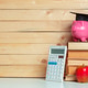 Piggy bank wears graduation hat with calculator and apple on wooden background Piggy bank wears graduation hat with calculator and apple on wooden background - PhotoDune Item for Sale