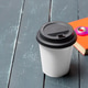 Coffee cup sits on a dark table next to a fidget spinner and a notebook Coffee cup sits on a dark table next to a fidget spinner and a notebook - PhotoDune Item for Sale