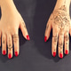 Hands with henna designs and red nail polish on a flat surface in a bright room Hands with henna designs and red nail polish on a flat surface in a bright room - PhotoDune Item for Sale