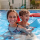 Young woman and boy laugh, splashing together in a sunny pool Young woman and boy laugh, splashing together in a sunny pool - PhotoDune Item for Sale
