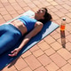 Woman relaxing on yoga mat outdoors after workout Woman relaxing on yoga mat outdoors after workout - PhotoDune Item for Sale