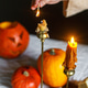 Making jack o lantern. Woman hands lighing up candles and carving pumpkins on table Making jack o lantern. Woman hands lighing up candles and carving pumpkins on table - PhotoDune Item for Sale