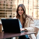 Young woman working remotely on laptop outdoors at cafe Young woman working remotely on laptop outdoors at cafe - PhotoDune Item for Sale