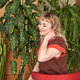 Smiling woman relaxing in modern indoor garden with lush greenery and red chair Smiling woman relaxing in modern indoor garden with lush greenery and red chair - PhotoDune Item for Sale