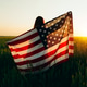 Young woman with American flag in a wheat field at sunset. 4th of July. Patriotic holiday. Young woman with American flag in a wheat field at sunset. 4th of July. Patriotic holiday. - PhotoDune Item for Sale