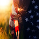 Woman with the American flag running in a wheat field at sunset. 4th of July. Independence Day, Woman with the American flag running in a wheat field at sunset. 4th of July. Independence Day, - PhotoDune Item for Sale