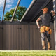 Worker stands under the structure at a construction site during daytime Worker stands under the structure at a construction site during daytime - PhotoDune Item for Sale