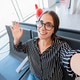 Young woman taking selfie waving hand inside airport Young woman taking selfie waving hand inside airport - PhotoDune Item for Sale
