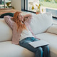 Redhead woman relaxing on sofa thinking after work Redhead woman relaxing on sofa thinking after work - PhotoDune Item for Sale